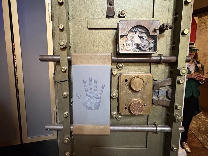 Antique brass bank vault with a gray pad with the outline of a hand