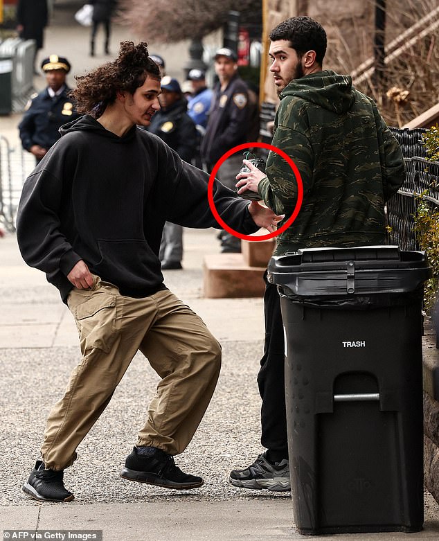 Emir Balat hands Ibrahim Kayumi a homemade explosive device during a protest organized by far-right influencer Jake Lang against alleged "Islamification" and to ask for a "stop of public Muslim prayer" in New York in front of Gracie Mansion on Saturday
