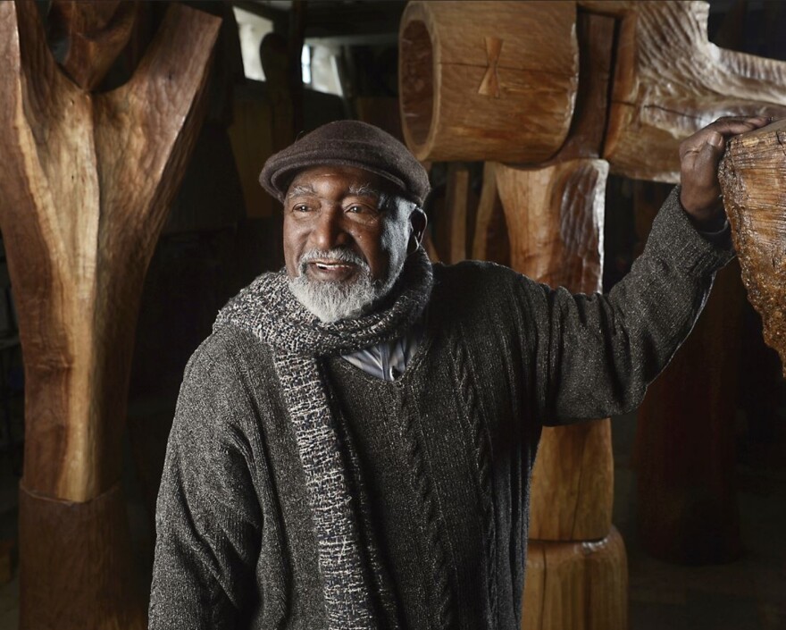 Man poses with sculpture