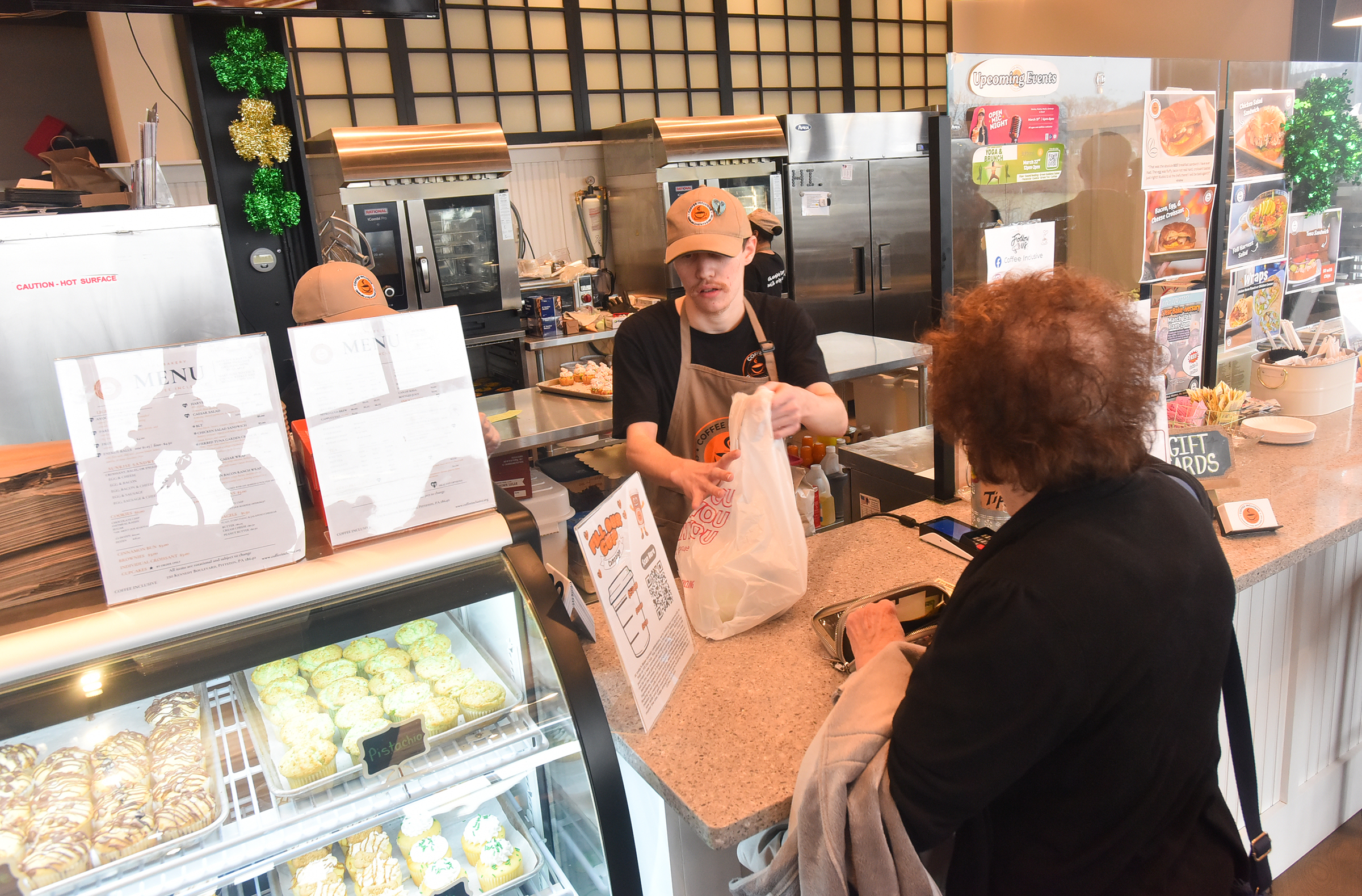 Employee Brian Boston checks out a customer at Coffee Inclusive...