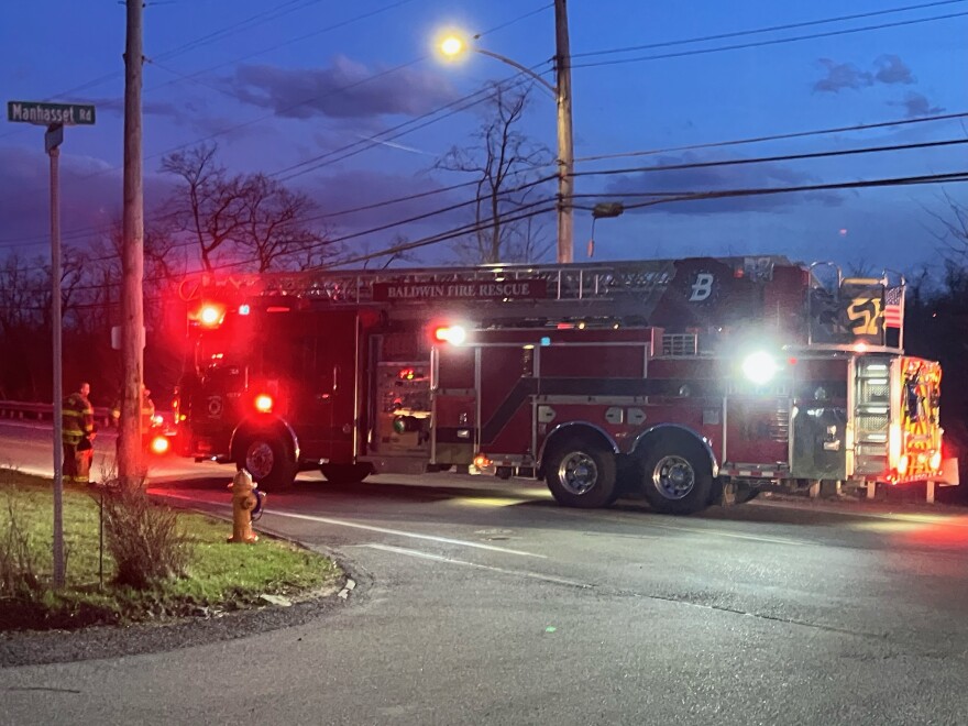 A fire engine blocks a street after high winds swept through the neighborhood
