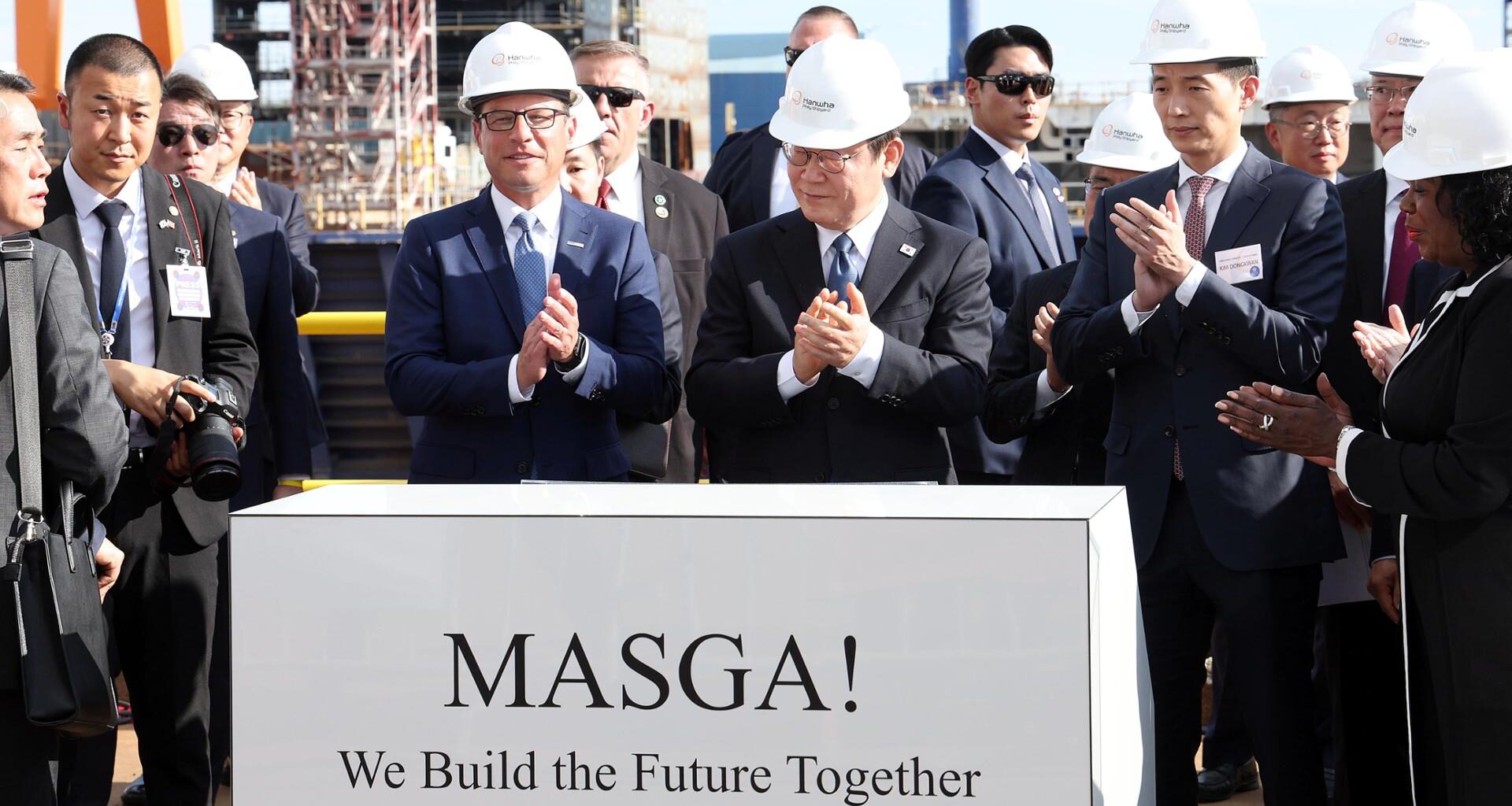 Korean President Lee Jae Myung, center, alongside Pennsylvania Gov. Josh Shapiro, left, and Hanwha Group Vice Chairman Kim Dong-kwan, applauds during a visit to Hanwha Philly Shipyard, owned by Korean shipbuilder Hanwha Ocean, in Philadelphia, Aug. 26, 2025. Yonhap