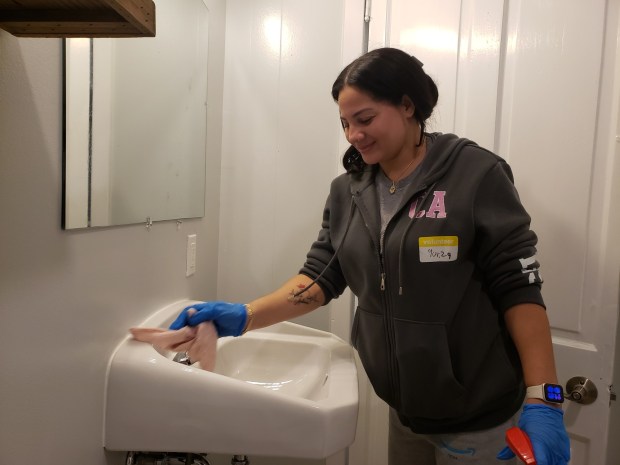 Yuliza Contreras of Legend Truck Body and Premier Fleet Services, Leesport, cleans a bathroom at Hope House in time to welcome 13 residents to the refurbished group home on South Ninth Street. (MICHELLE LYNCH/READING EAGLE)