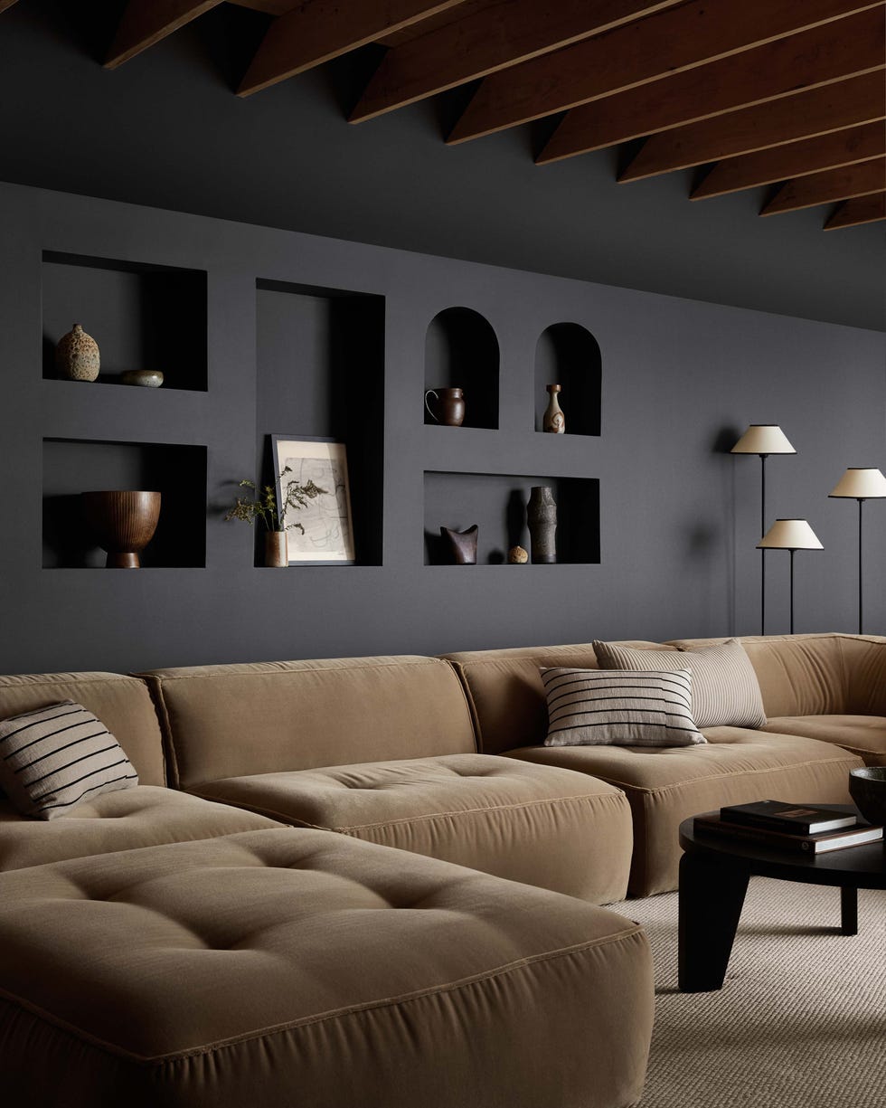 Modern living room with sectional sofa and decorative elements.