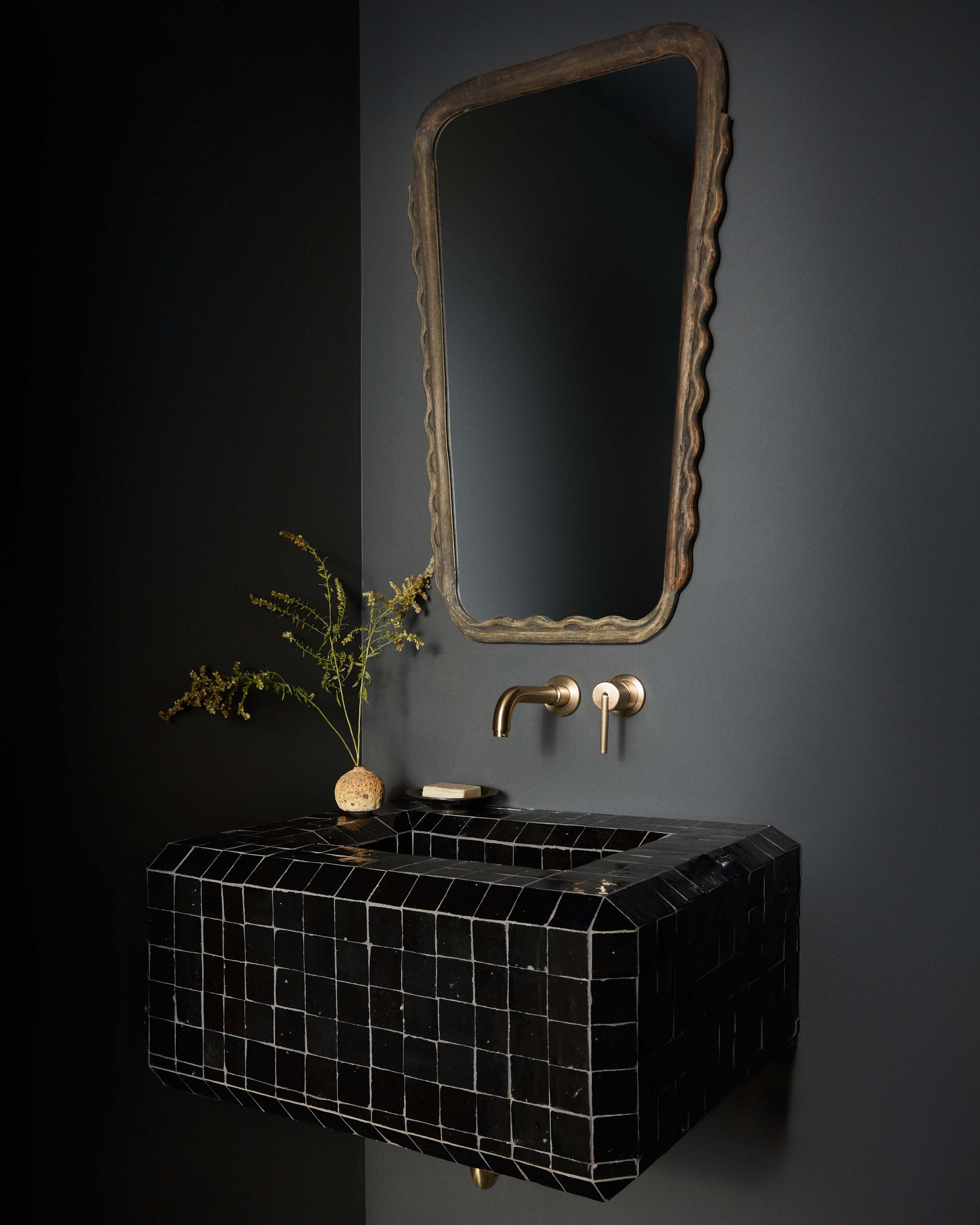 Modern bathroom sink setup with a decorative mirror.