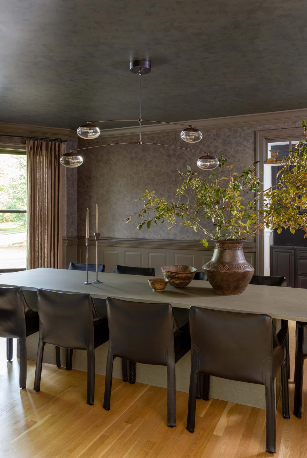 Modern dining area featuring a long table with seating and decorative elements.