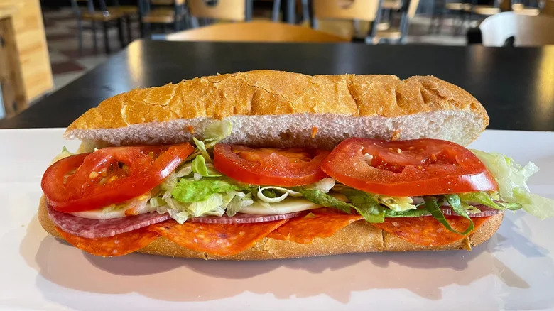 Italian hoagie with meat, cheese, and vegetables on a restaurant countertop