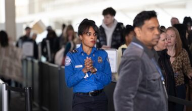 TSA agent Kelly Jonson assists travelers through a busy security line at Gate Section B at Philadelphia International Airport last week.