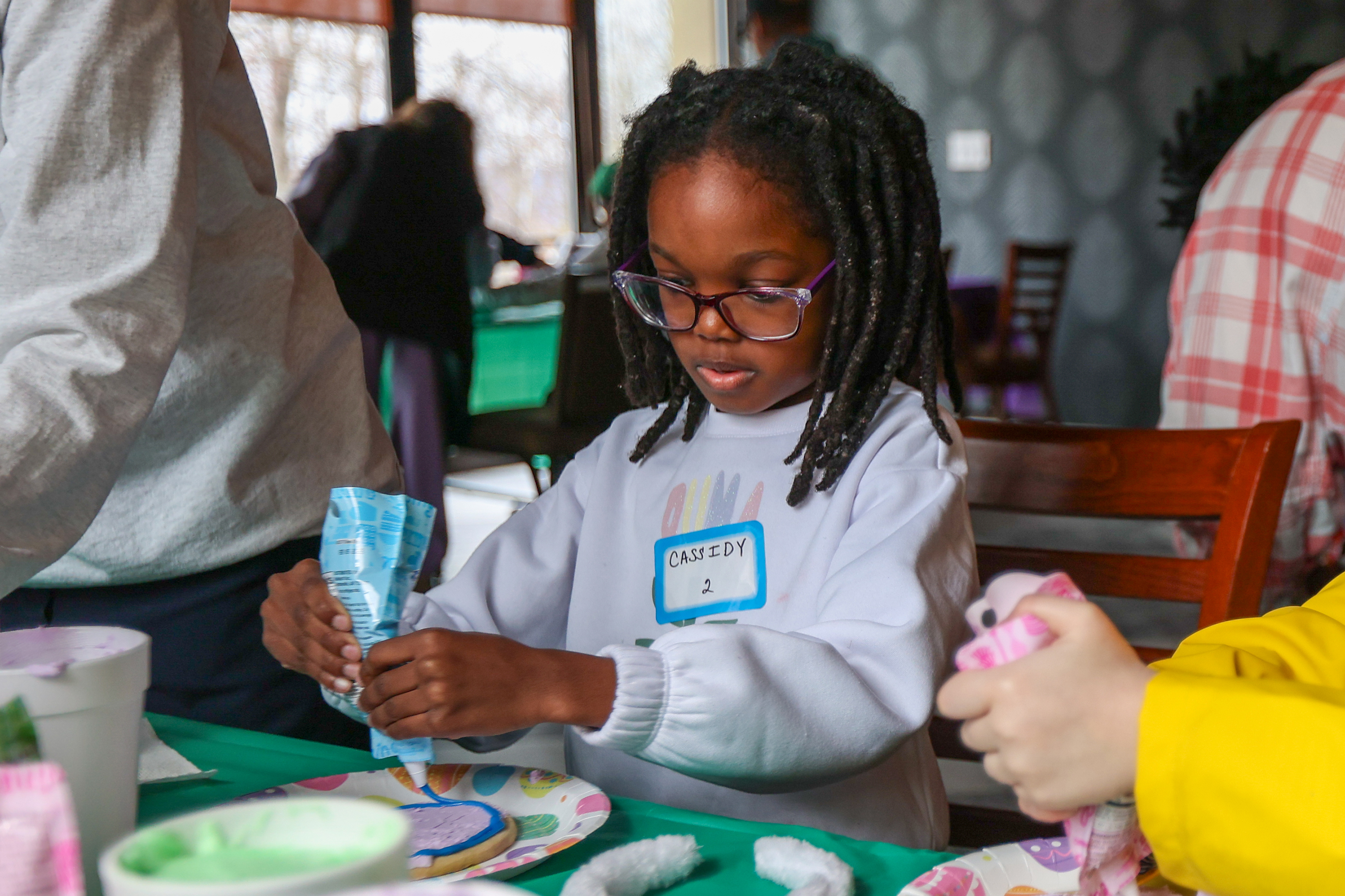 Cassidy Pierre, 7, of Plymouth, decorates a cookie during the...