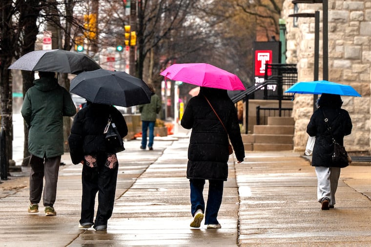 Pedestrians walks on the Temple University campus as rain falls on Feb. 22 before the snows came.