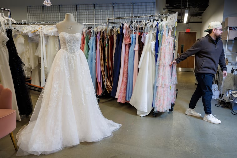 Shane Skoda, producer and studio manager, moves a rack of dresses at David's Bridal headquarters in King of Prussia.