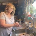 A woman stands by her kitchen sink