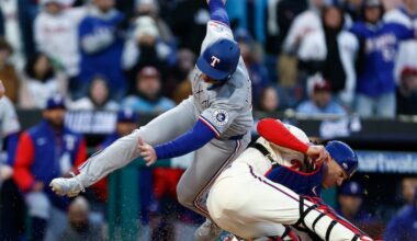The Rangers' Wyatt Langford collides with Phillies catcher J.T. Realmuto in the 10th inning on Saturday.