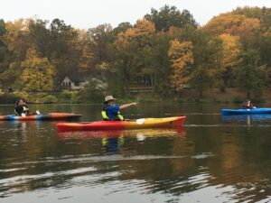 Three kayaks skim the lake at North Park to look at fall foilage.