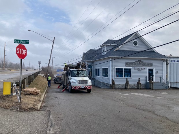 A crew preparing to replace a utility pole at Beaver Park Marina in Lorain where a vehicle crashed and ended up in Lake Erie where the female occupants died. (Journal staff - The Morning Journal)