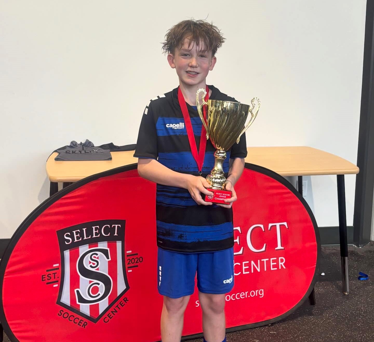 Budding soccer star Miko Donis holds the Championship Cup at...