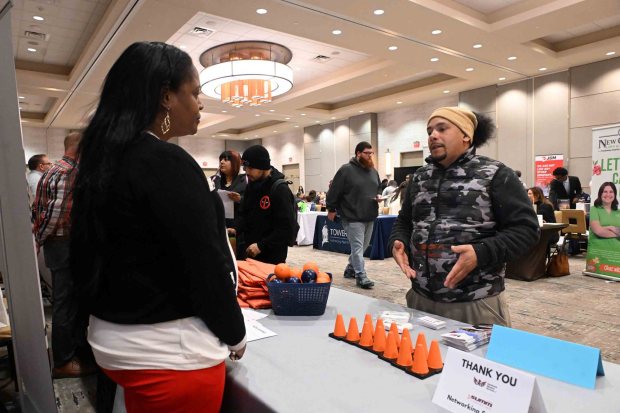 Ruth Besson, human resources manager for Summit Flagging, talks with Jayson Cuadrado of Reading about employment opportunities during the Connections Work Job Fair held at the DoubleTree by Hilton hotel, 701 Penn St., on March 9. (BILL UHRICH/READING EAGLE)