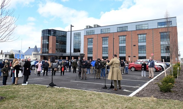 Dr. Khalid Mumin, Reading School District superintendent, says the dedication of a Habitat for Humanity home in the 900 block of Douglass Street on Tuesday will help students of the soon-to-open Innovation Academy, in the background, understand the possibilities available in their own city. (BILL UHRICH/READING EAGLE)