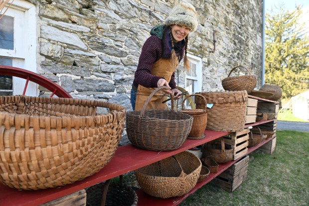Laura Reppert of Lobachsville displays baskets made in the 18th and 19th centuries that are part of the heritage center's collection during the Easter on the Farm celebration at the Pennsylvania German Cultural Heritage Center at Kutztown University on Saturday, March 28, 2026. (BILL UHRICH/READING EAGLE)