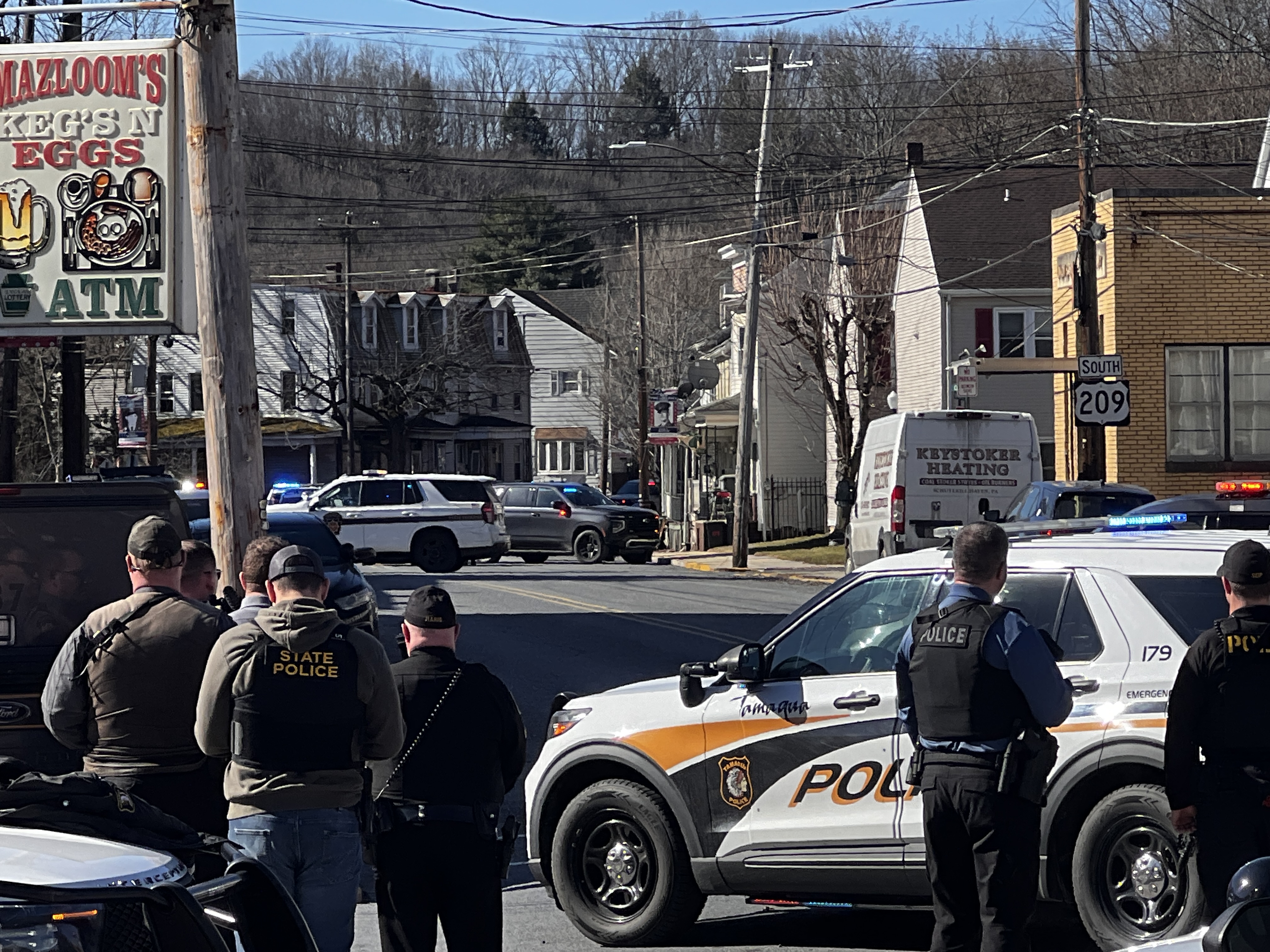 State and local police position around a home on the...