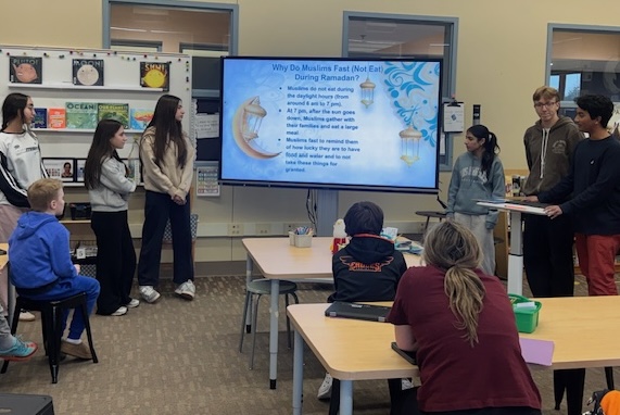 students standing near large TV screen