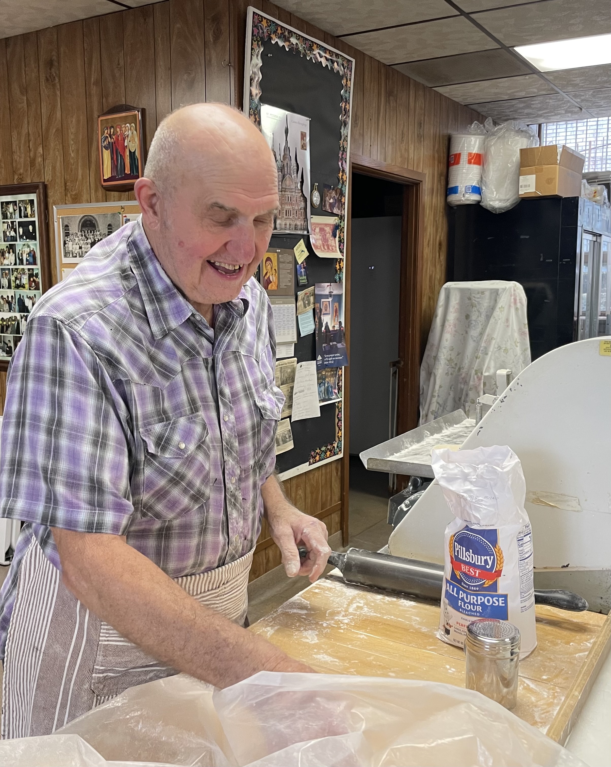 Joe Schlasta rolls out the pierogi dough on the machine...