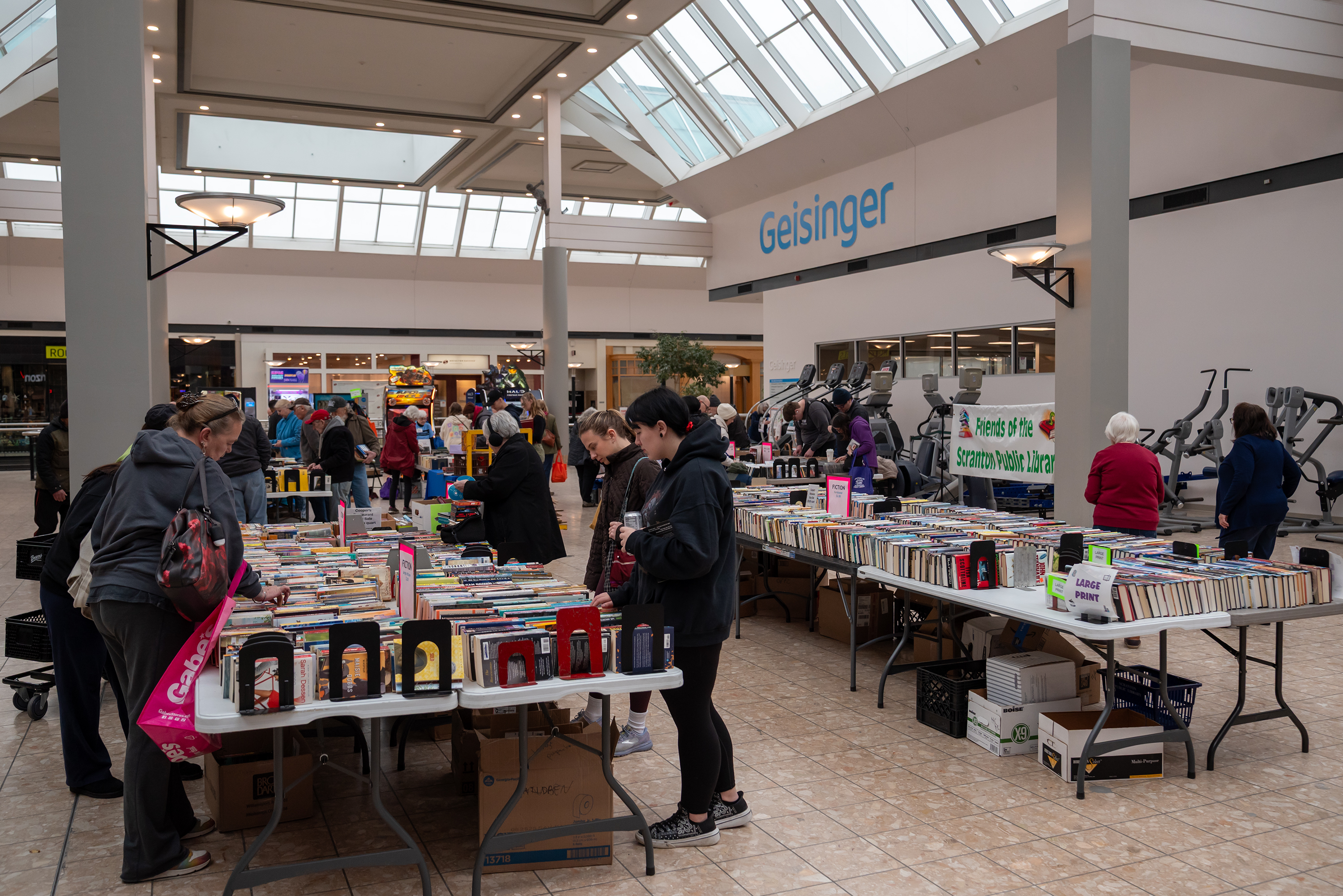 Community members browse through the variety of titles, CDs, DVDs,...