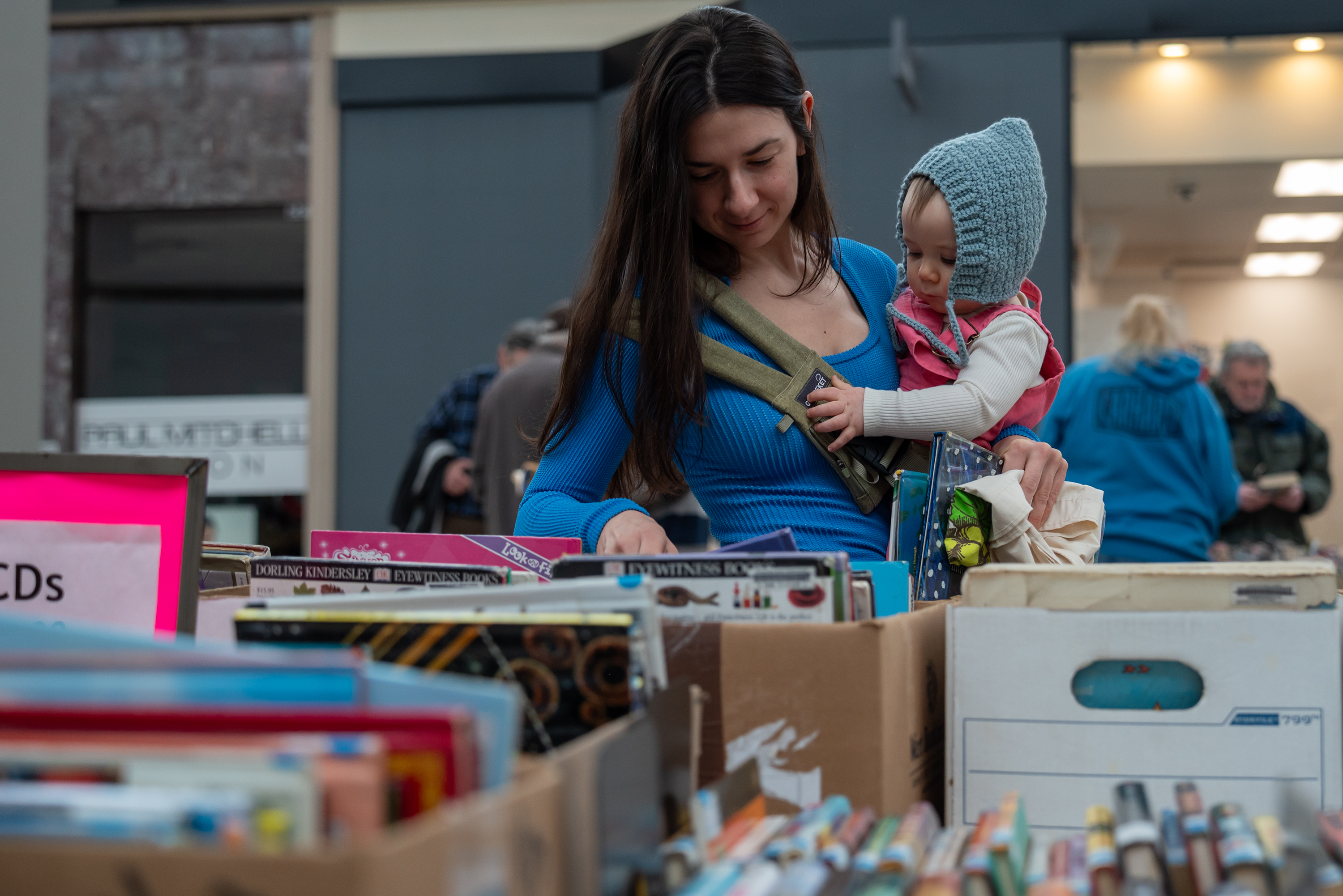 Gabby Filipski holds her daughter Isla while looking for children’s...