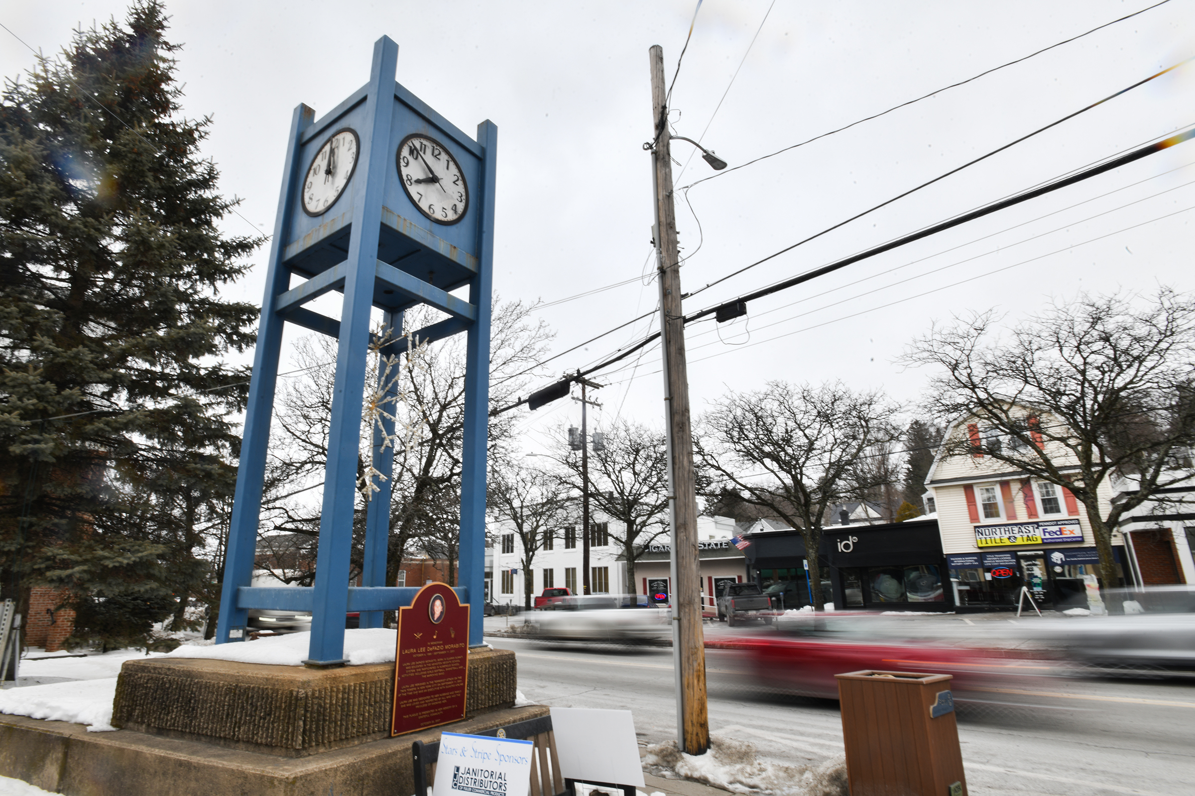 Vehicles pass the clock tower on State Street in Clarks...