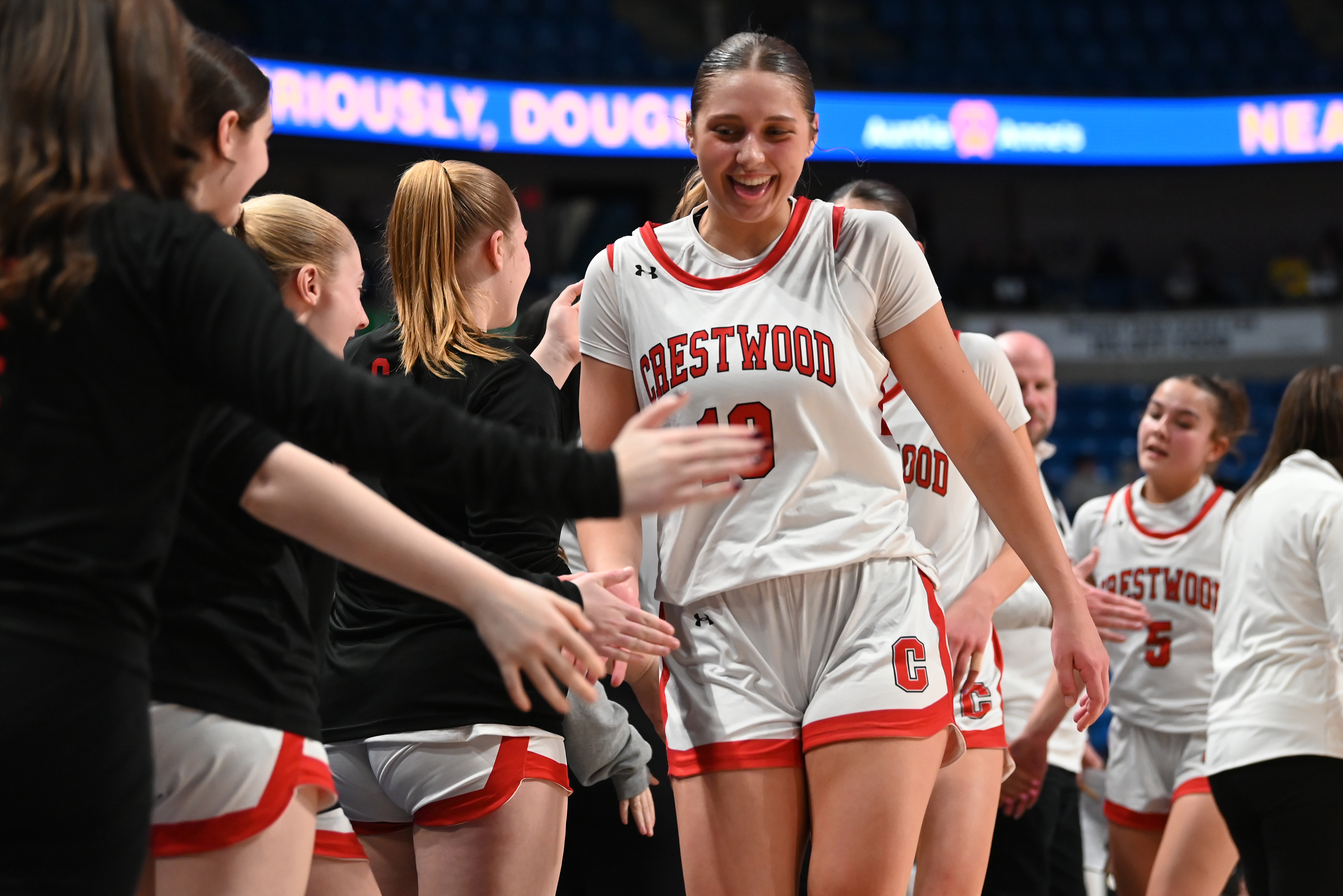 Crestwood’s Charlie Hiller high-fives her teammates as she returns to...