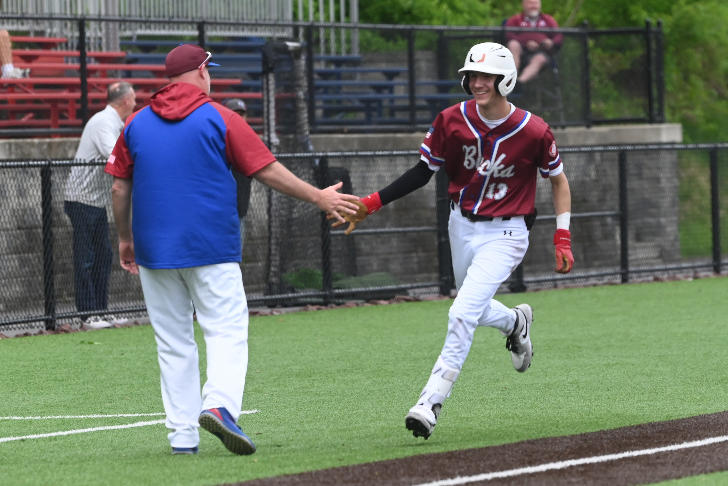 Dunmore’s Mason Stets high-fives coach Sid Hallinan during the baseball...
