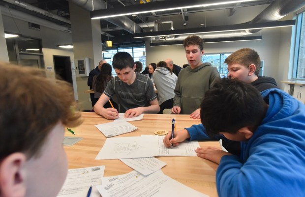 Old Forge eighth-grade students, from center left, Coleman Nee, Ethan Granko, Chris Sica, Gaetano Lubrano, and Jacob Poehlman, work on their design during an entrepreneurial workshop at the University of Scranton's IDEA Center in Weiss Hall on the Scranton campus Thursday, March 19, 2026. (SEAN MCKEAG / STAFF PHOTOGRAPHER)