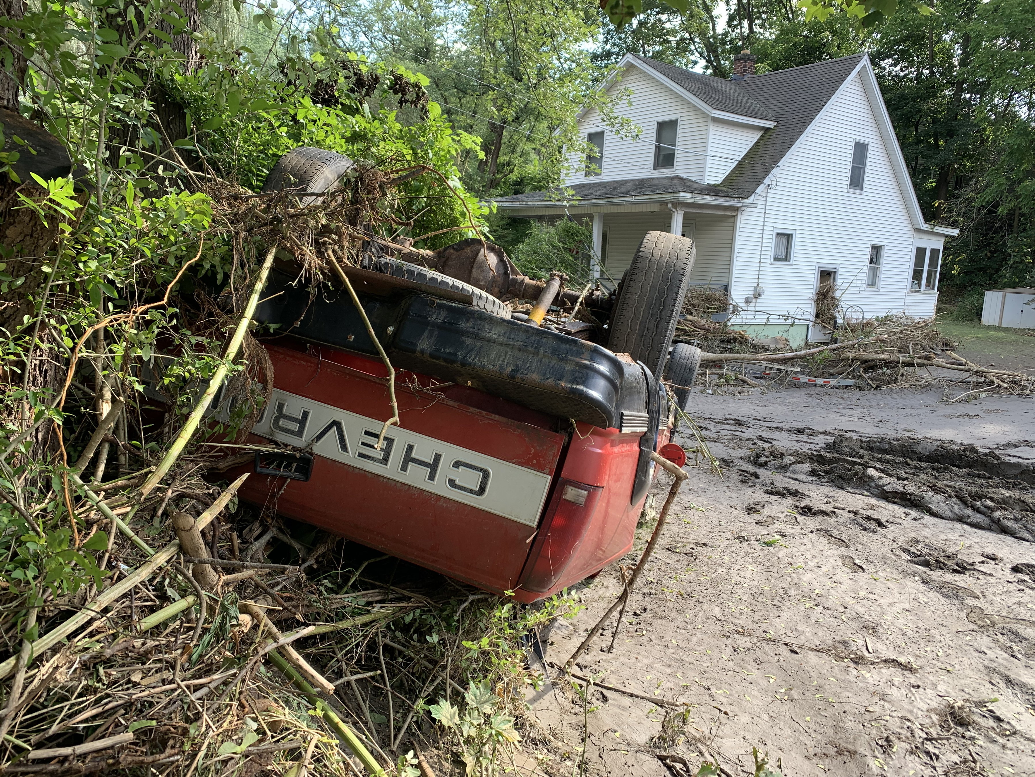 A pickup truck flipped onto its roof by flood waters...
