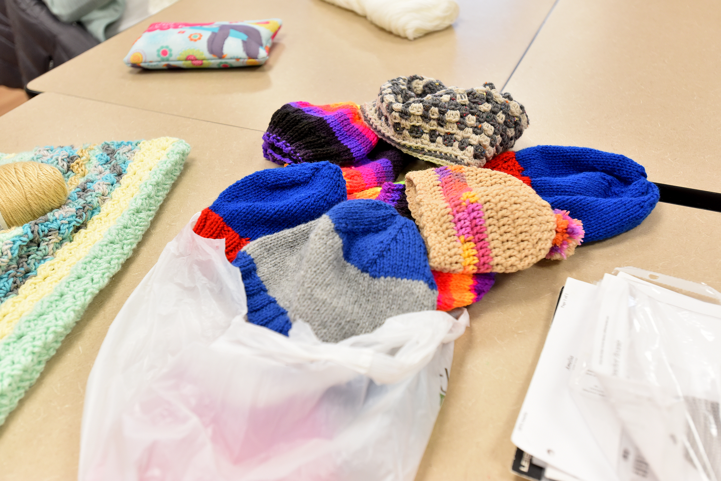 Hats sit on the table, created by the group “Caring...