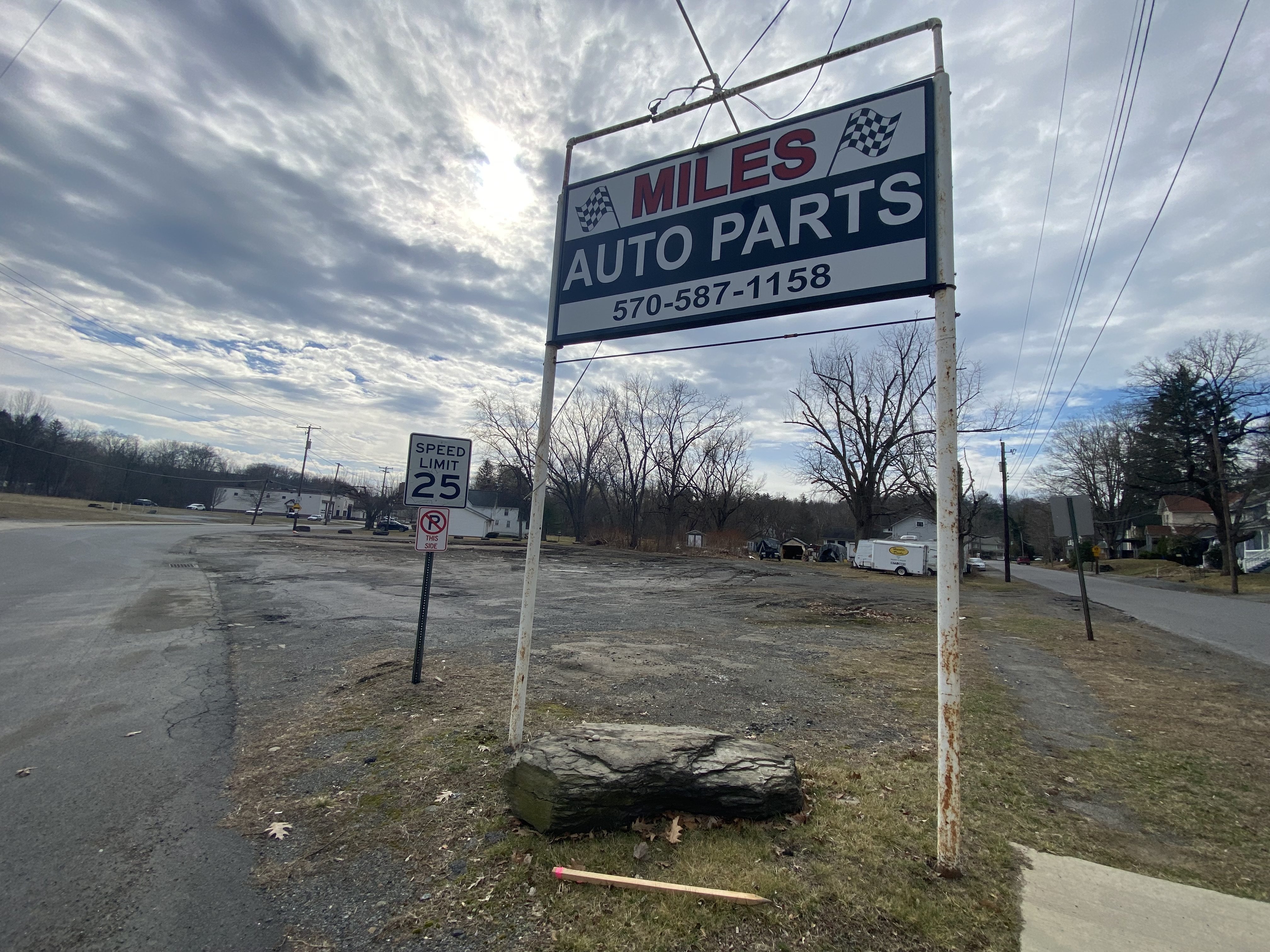 The sign for Miles Auto Parts sits on the site...