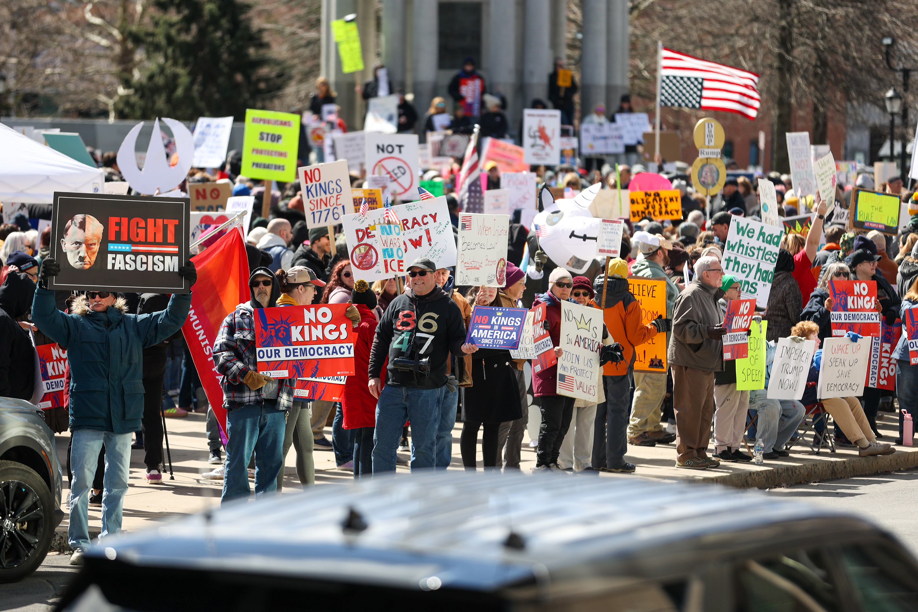 Attendees gather on Courthouse Square and hold their signs during...