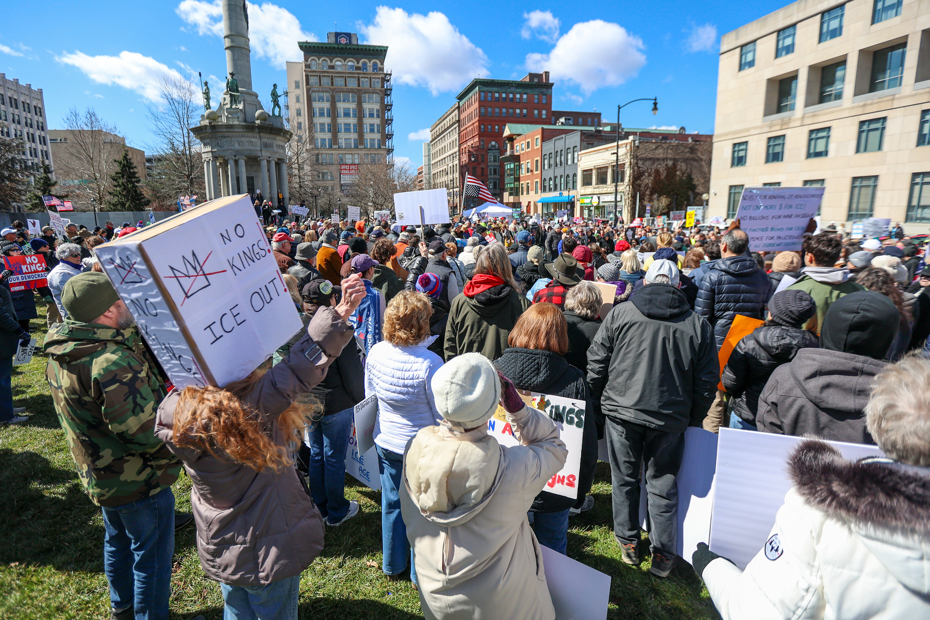 Attendees gather on Courthouse Square and hold their signs during...