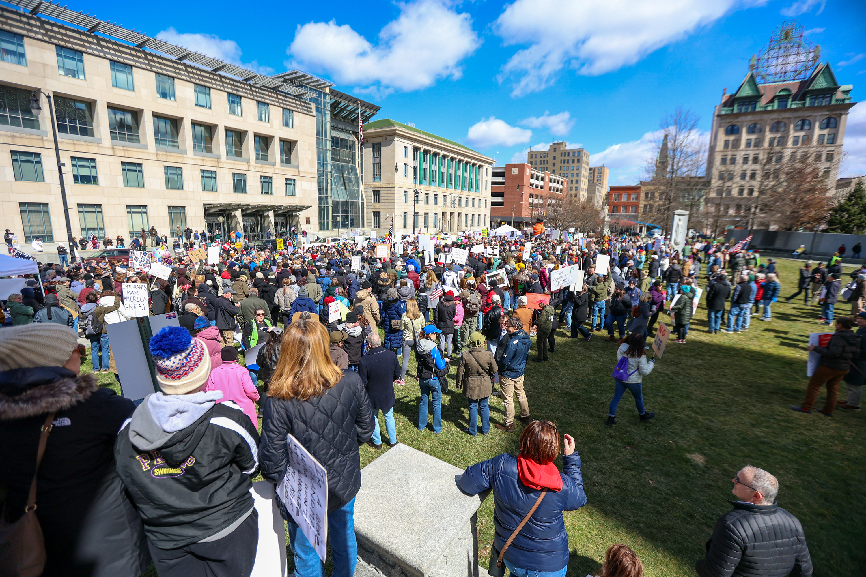 Attendees gather on Courthouse Square and hold their signs during...