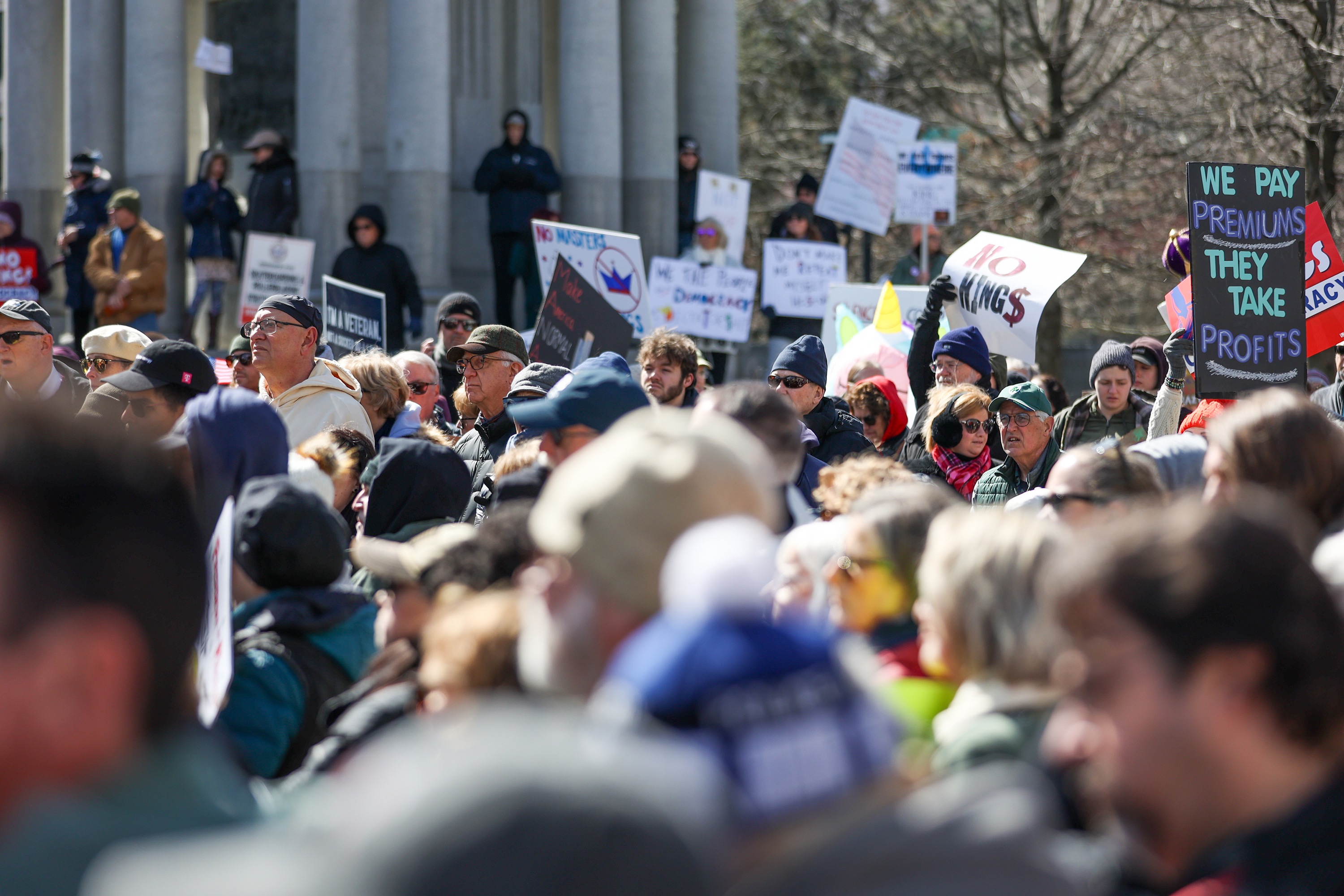 Attendees gather on Courthouse Square and hold their signs during...