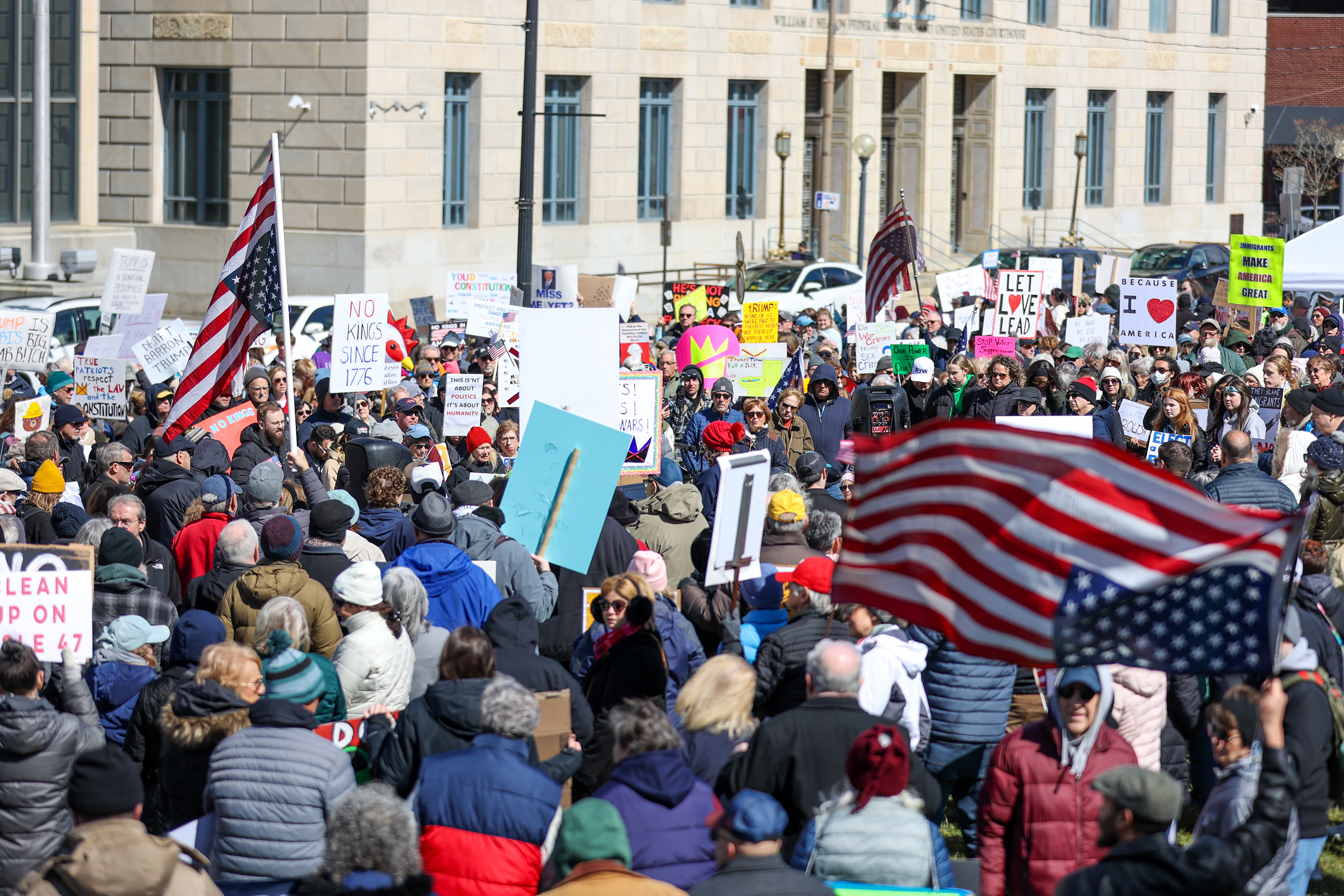 Attendees gather on Courthouse Square and hold their signs during...