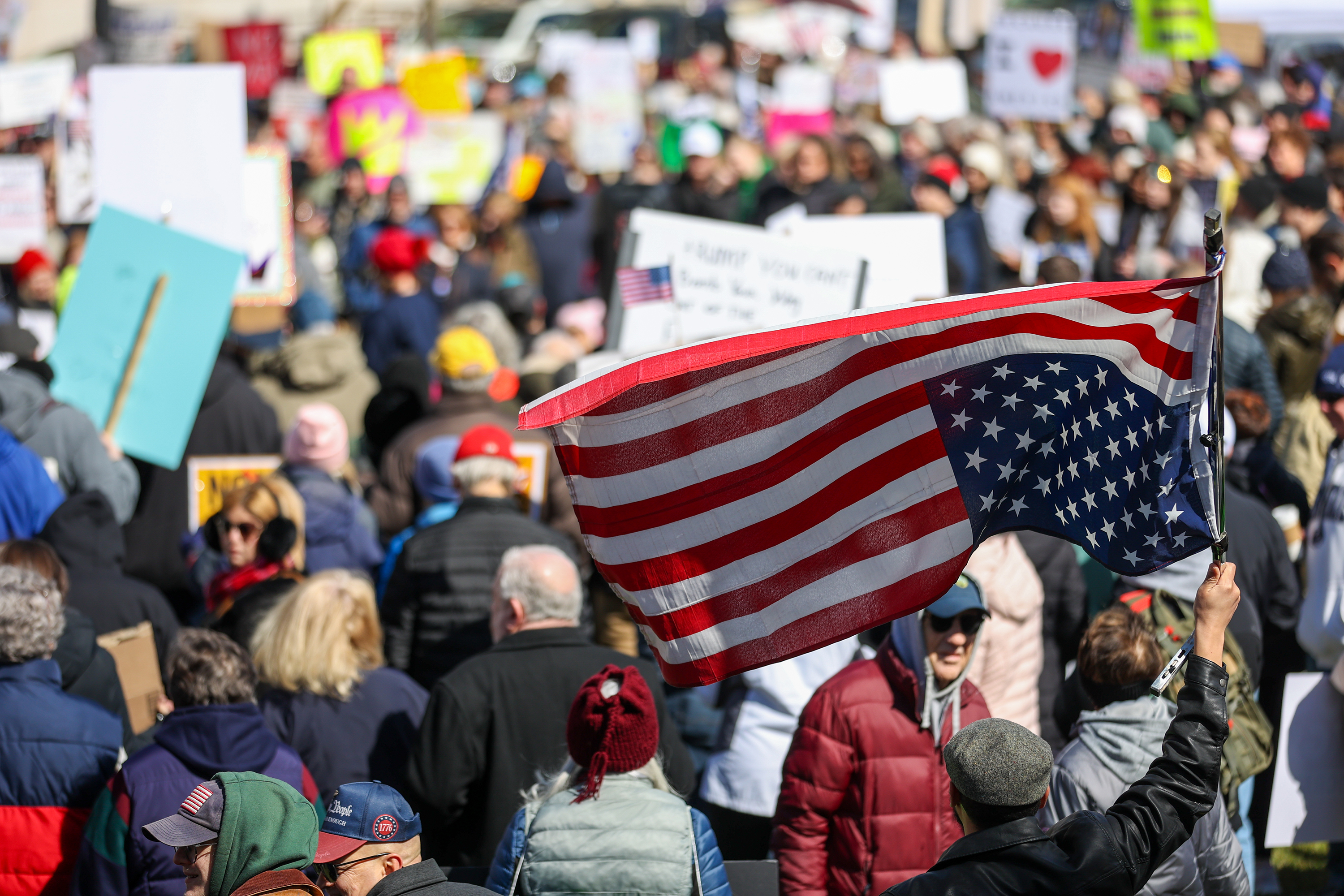 An attendee waves an upside-down U.S. flag during the ‘No...