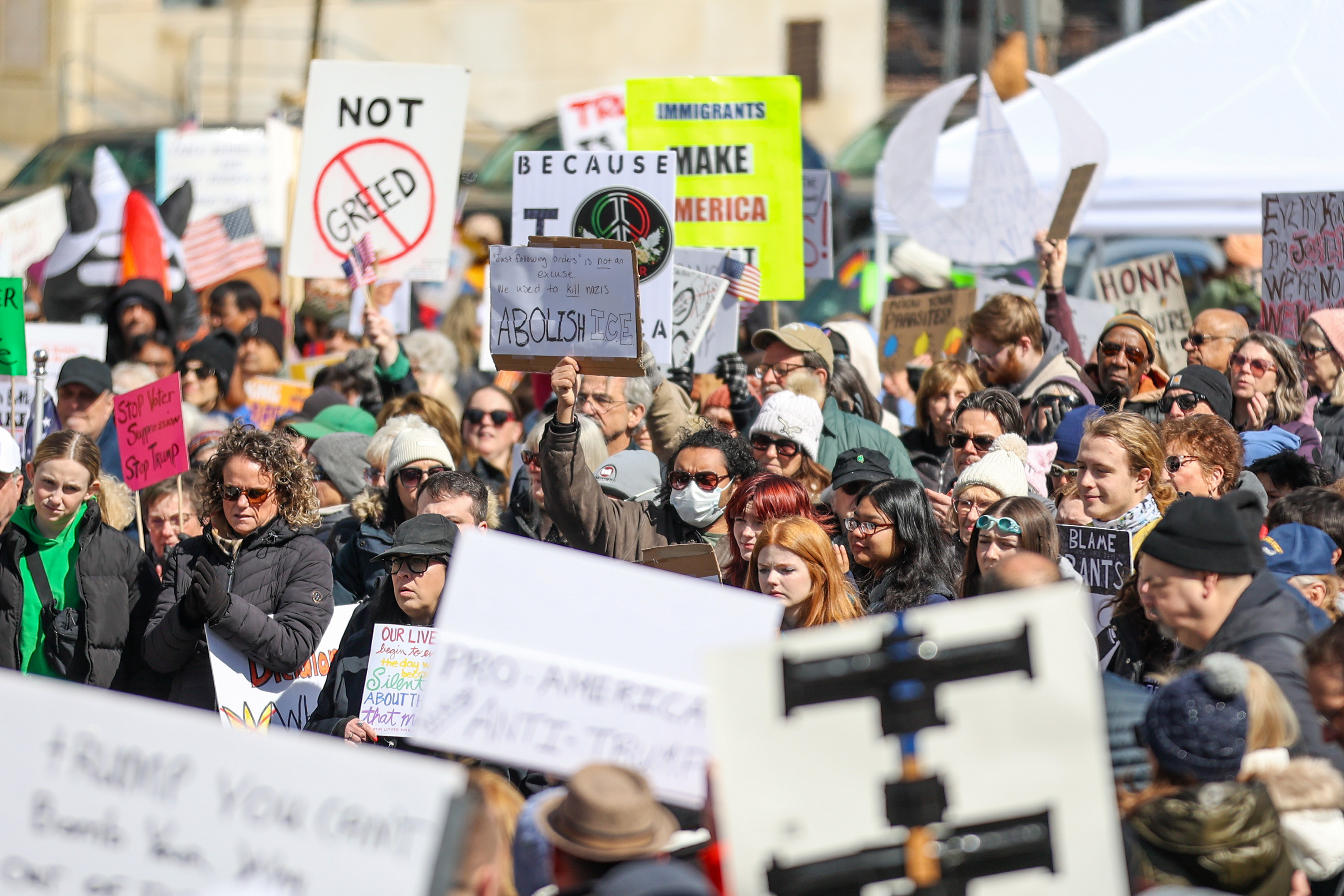 Attendees gather on Courthouse Square and hold their signs during...
