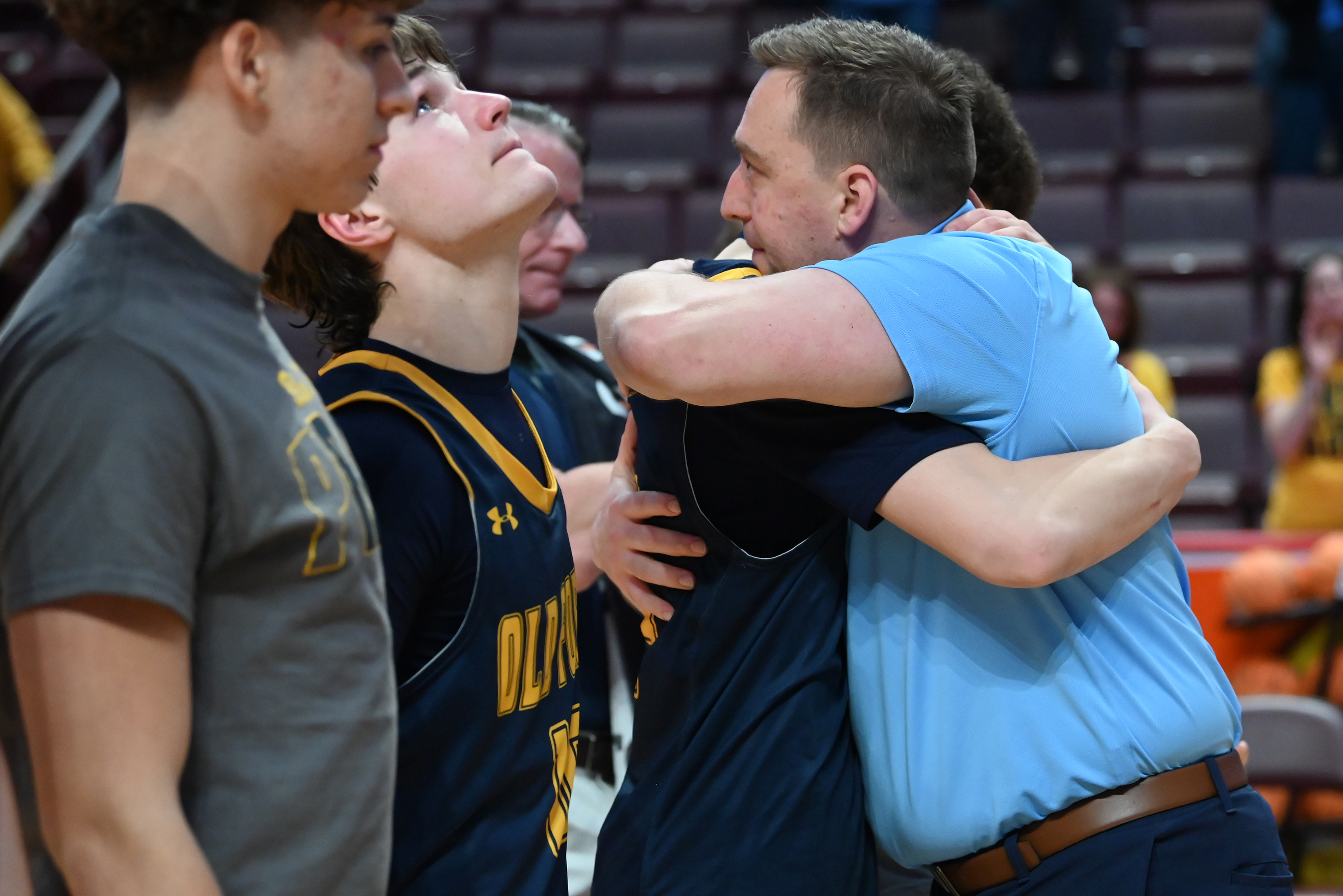 Old Forge’s head coach JJ Thomas hugs player Cameron Parker...