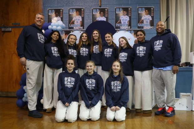 Lady Falcon players and coaches pose for a photo before the pep rally at Our Lady of Peace School in Clarks Green on Thursday, March 12, 2026. The 2025-26 team includes Francesca Colarusso, Maeve Hazzouri, Lauren Terrinoni, Gabby Ives, Francesca Paulino, Wilhelmina Walsh, Sistina Mariotti, Chloe Coslett, Lyla Weidow, and Cassie Sheehan, head coach Phil Odom, and assistant coaches Frank Coslett and Justin Bedford. (REBECCA PARTICKA/STAFF PHOTOGRAPHER)