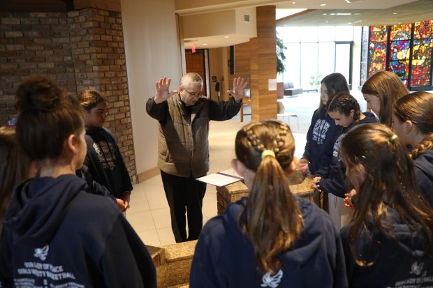 Father John Lapera blesses the varsity girls basketball team of Our Lady of Peace School at the Church of Saint Gregory in Clarks Green before they depart for the Catholic Youth Organization State Tournament in Philadelphia on Thursday, March 12, 2026. (REBECCA PARTICKA/STAFF PHOTOGRAPHER)