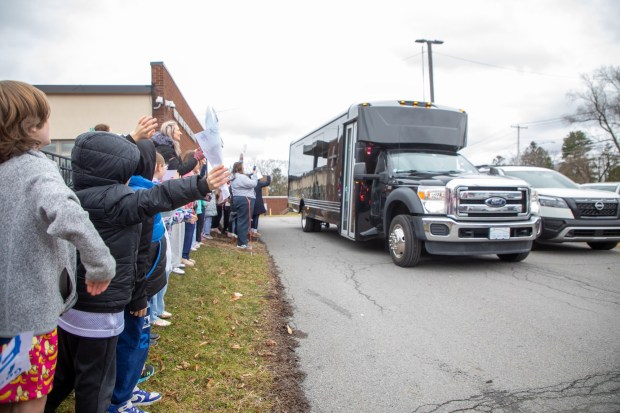 Students wave as the bus carrying the girls basketball team departs from Our Lady of Peace School for the Catholic Youth Organization State Tournament on Thursday, March 12, 2026. (REBECCA PARTICKA/STAFF PHOTOGRAPHER)