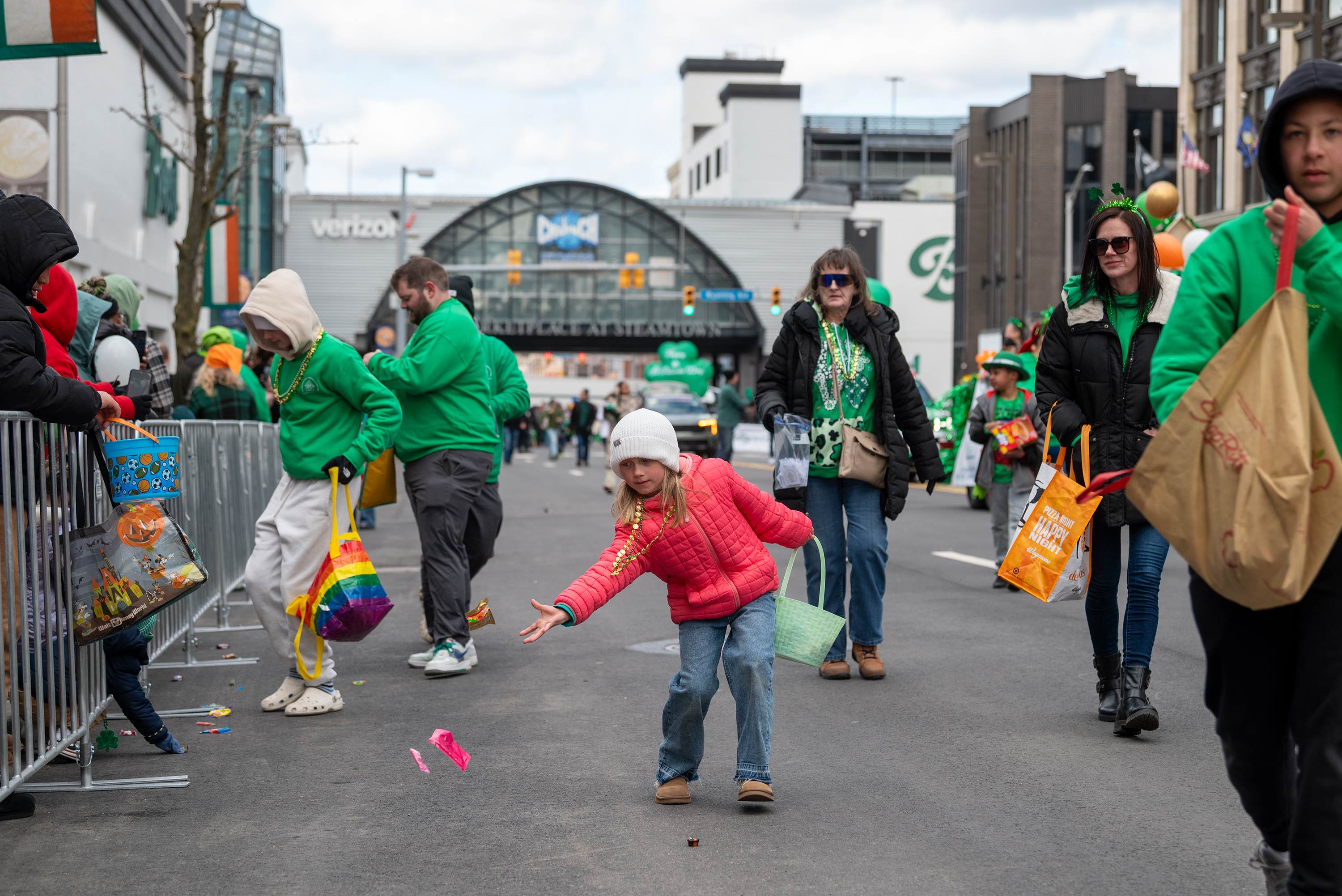Marchers toss candy during the St. Patrick’s Parade in downtown...