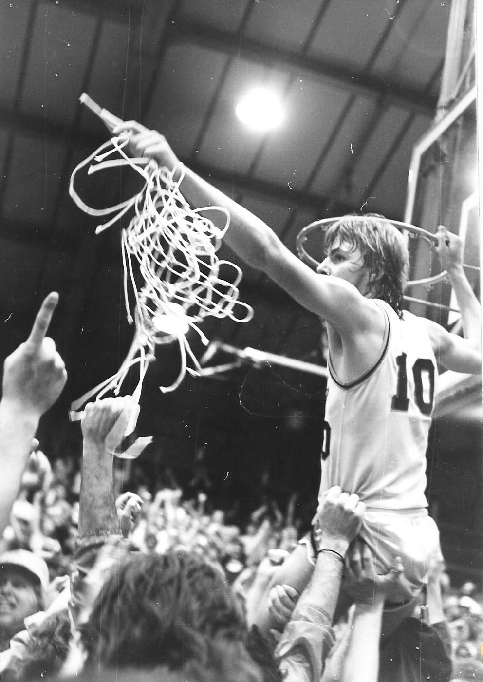 Sophomore guard Paul Miernicki cuts down the net after the...