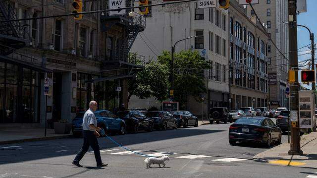 A man walks his dog in downtown Scranton, Pennsylvania on July 3, 2024. As residents of Joe Biden's hometown Scranton prepared to mark that most American of holidays -- July 4 -- many were also voicing alarm about the US president following his disastrous debate last week against Donald Trump. Scranton has long been the heart of the political mythology around Biden, recalling his hardscrabble upbringing, repaying his affection with an expressway named for him and a life-size cardboard cutout in Hank's Hoagies sandwich store (Photo by ANGELA WEISS / AFP) (Photo by ANGELA WEISS/AFP via Getty Images)