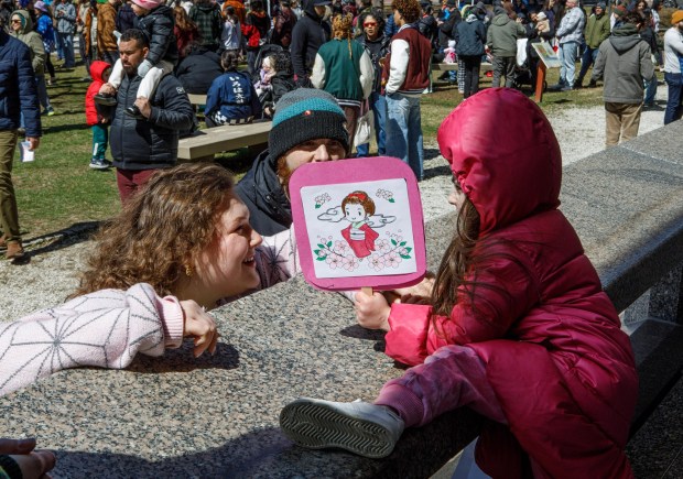 Violet Voyko, 4, of Salisbury hold a colored fan while talking with Celine Lembach of Bethlehem and her dad Kyle Voyko of Salisbury during the Bethlehem-Tondabayashi Sister City Commission's annual Cherry Blossom Festival on Saturday, March 28, 2026, at the Garden of Serenity in Bethlehem. The festival featured Japanese music, food, origami and tea ceremonies. (Jane Therese/Special to The Morning Call)